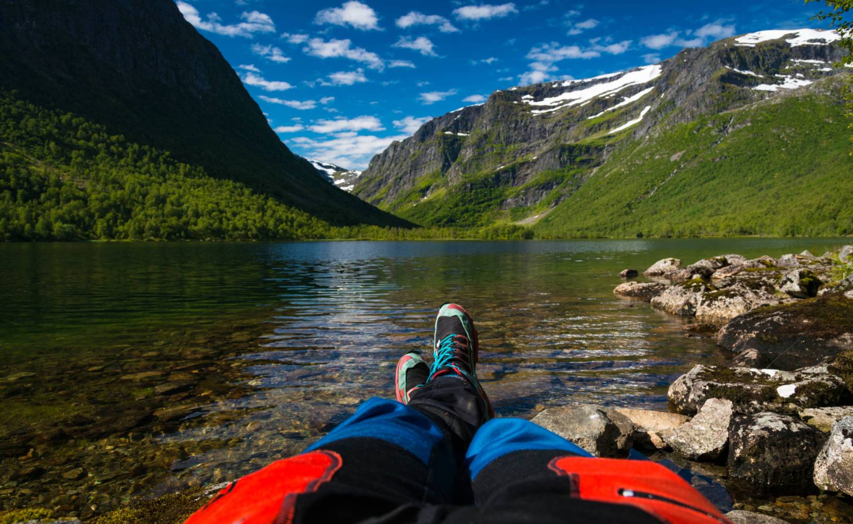 a man sitting on a rock next to water